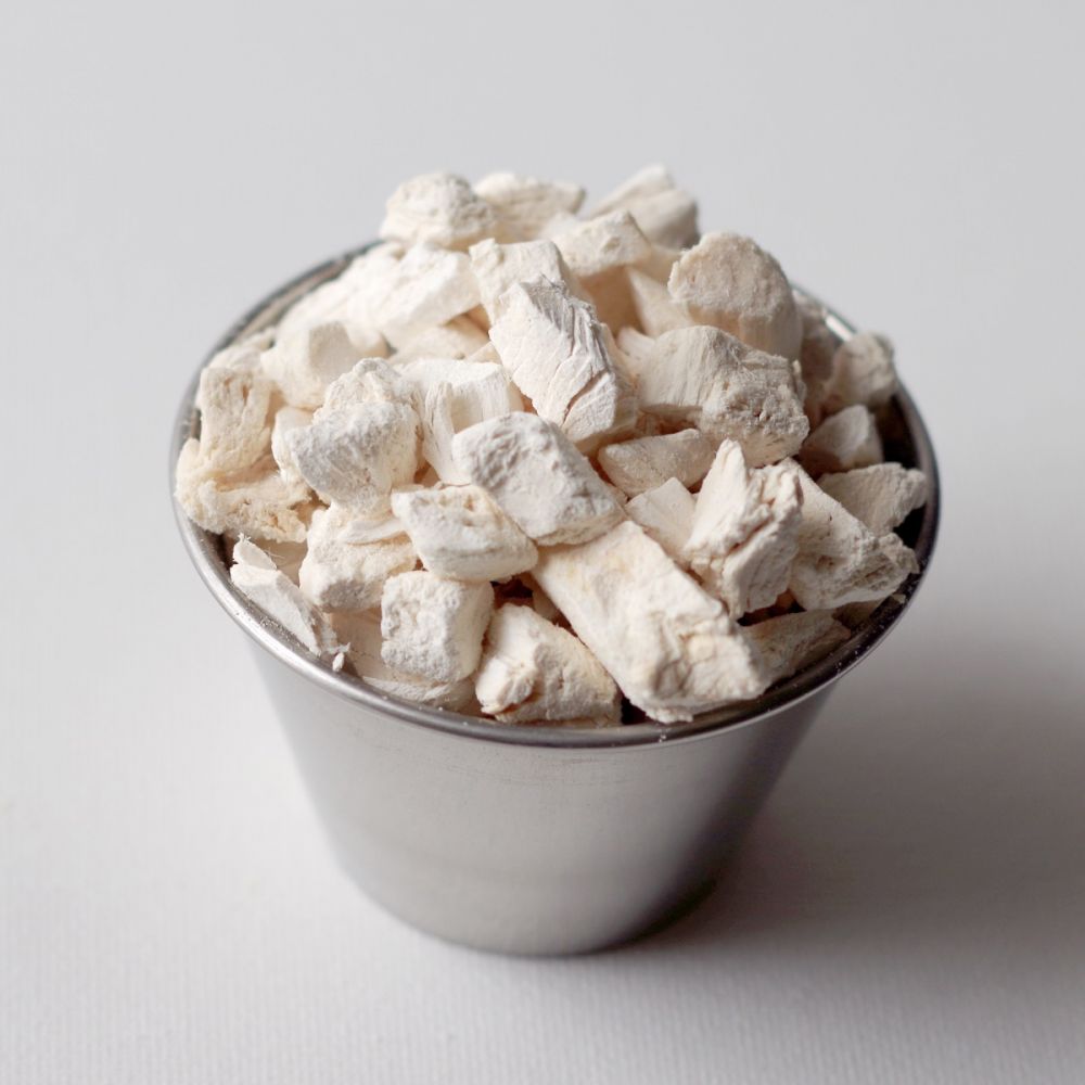 Freeze-dried tofu in a silver cup on a white surface.